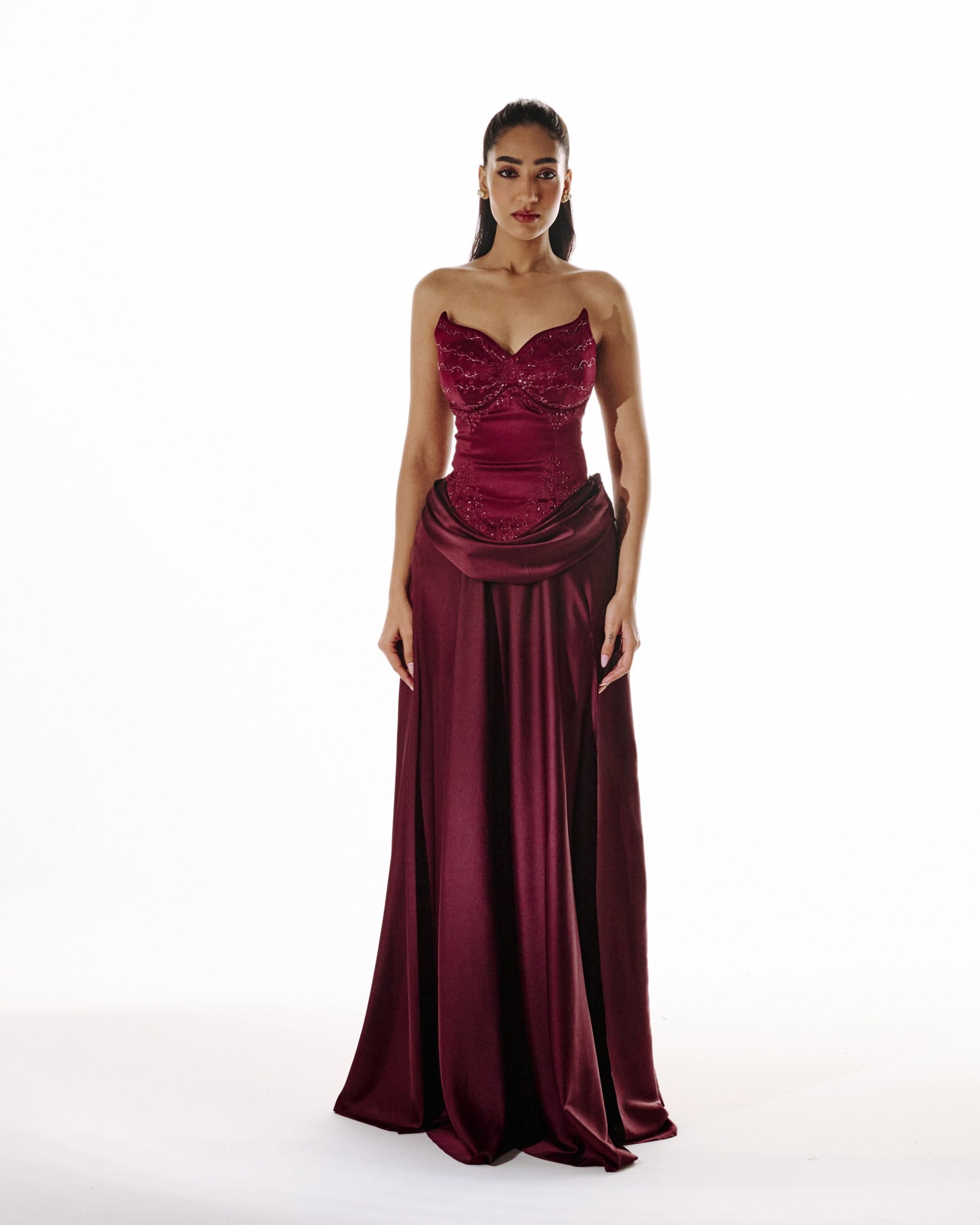 Woman wearing a burgundy evening gown on a white background