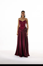Woman wearing a burgundy evening gown on a white background